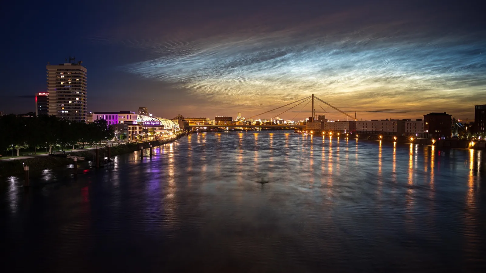 Rhein bei Nacht mit beleuchteter Uferpromenade und Brücke