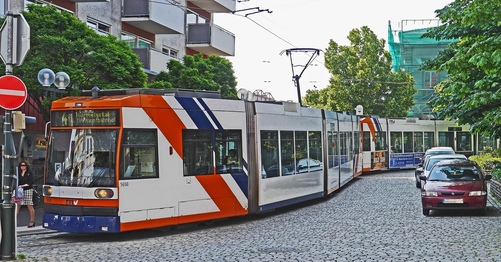 Straße in Ludwigshafen mit Straßenbahn, parkenden Autos und wenig freier Ladefläche für einen Umzugswagen